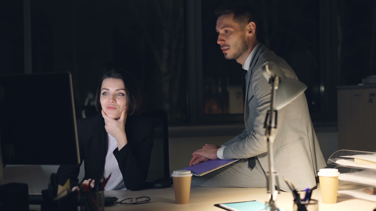 Two colleagues laughing over a screen