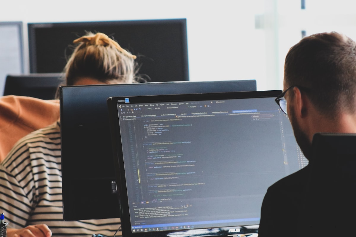 Two people building a website on screen